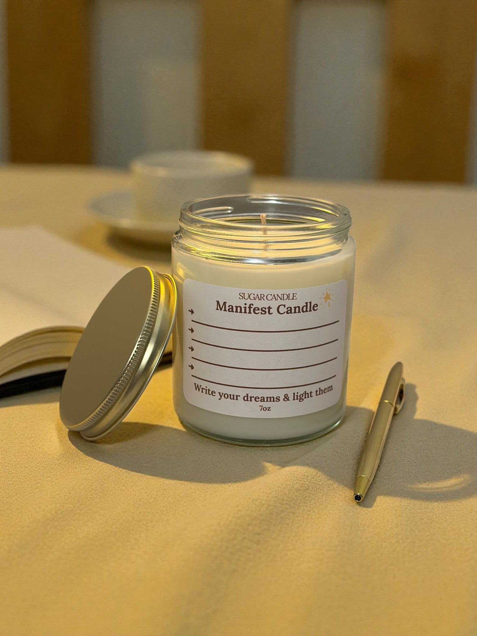 Manifest candle with a label on a table with a pen and notebook