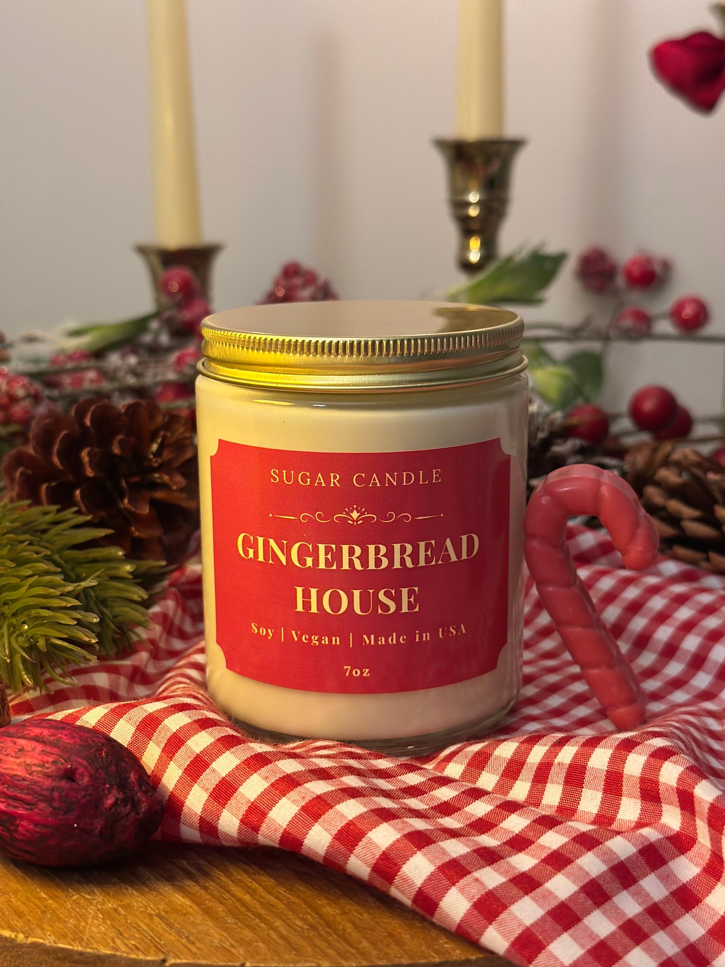 Candle labeled 'Gingerbread House' with a red and white checkered cloth in the background