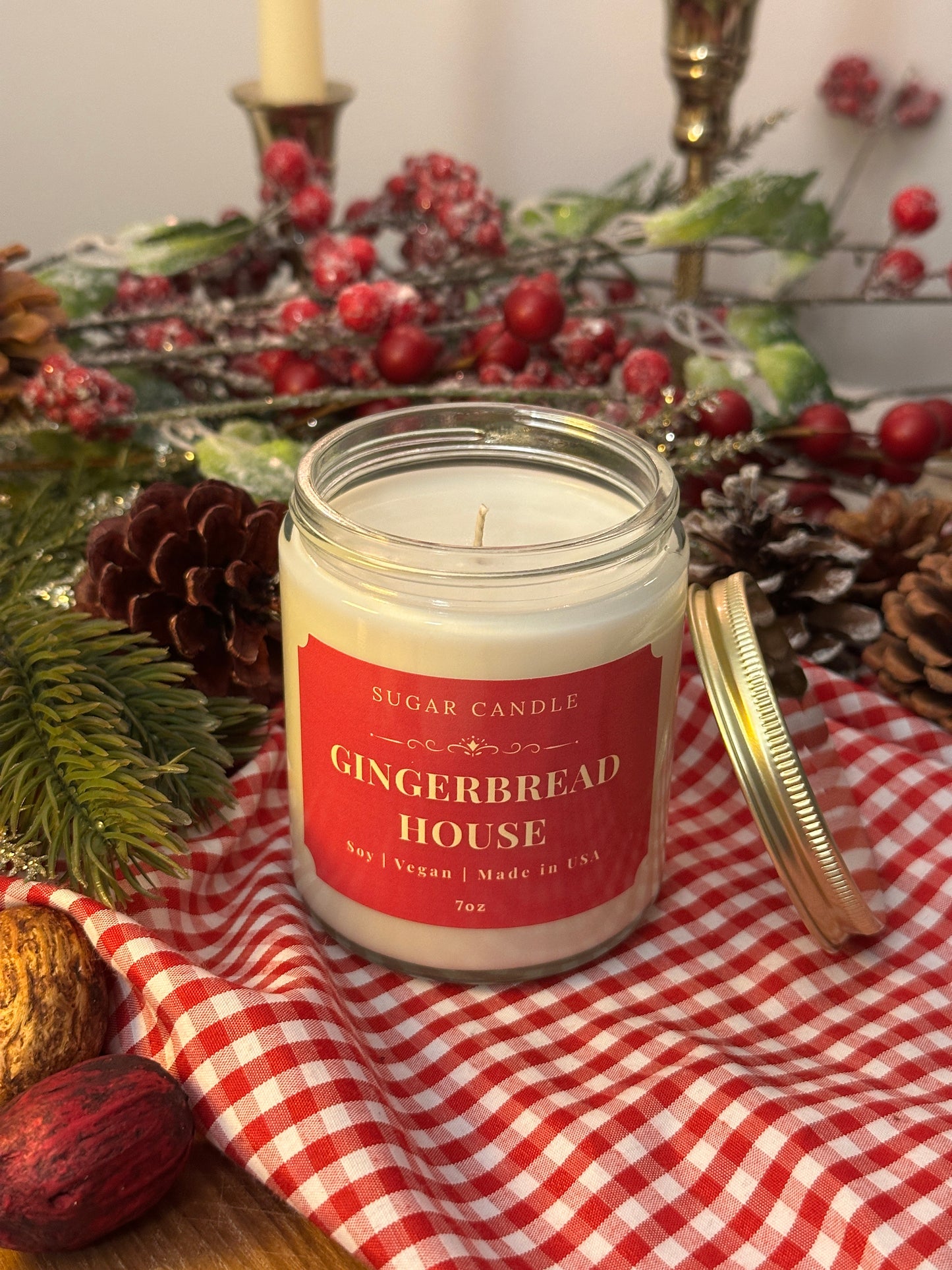 Gingerbread House candle on a table with Christmas decorations