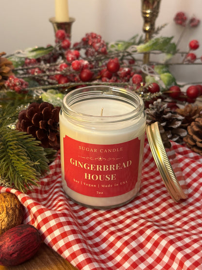 Gingerbread House candle on a table with Christmas decorations