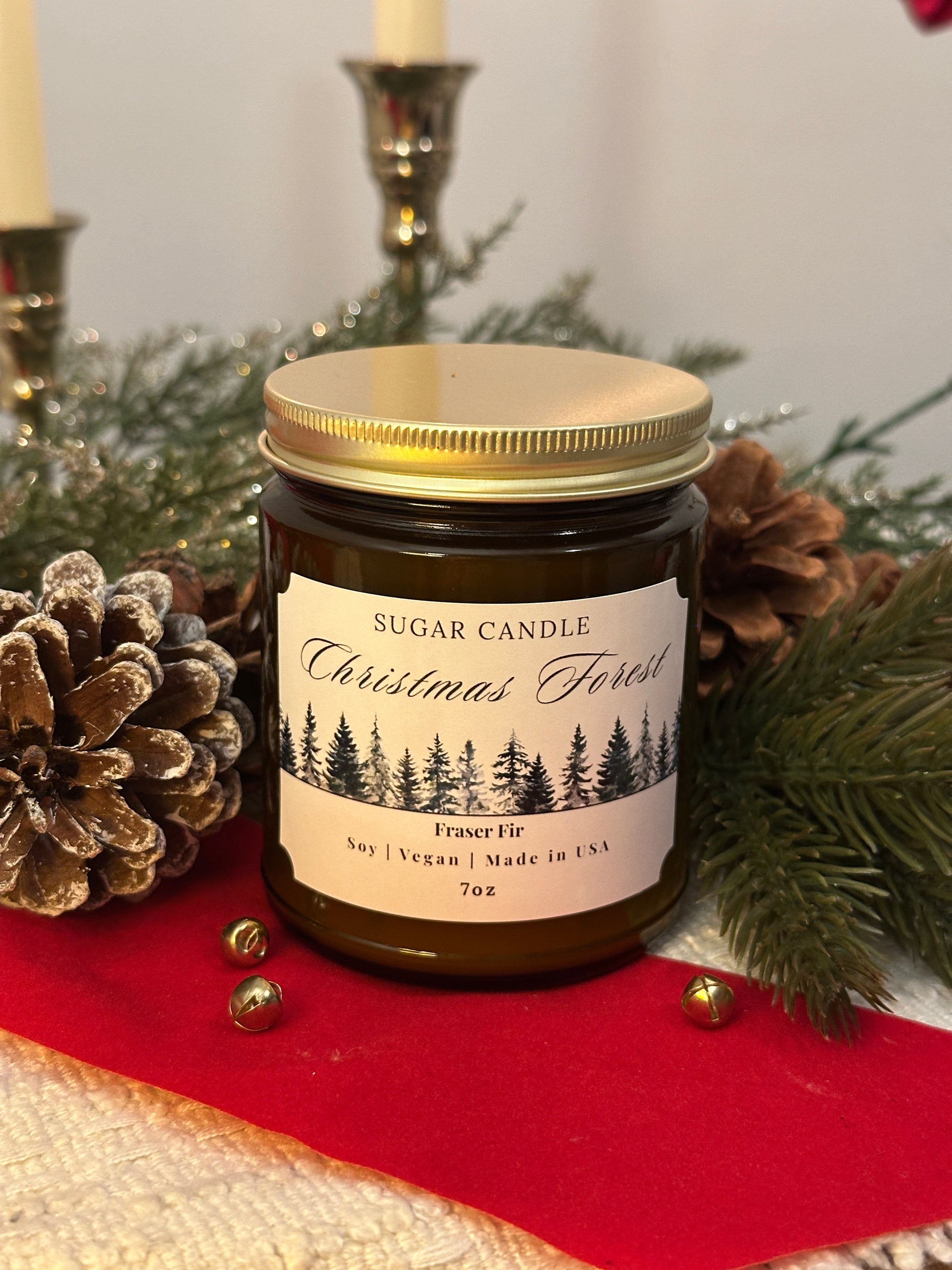 Jar of Christmas-themed candle with decorative elements on a red surface