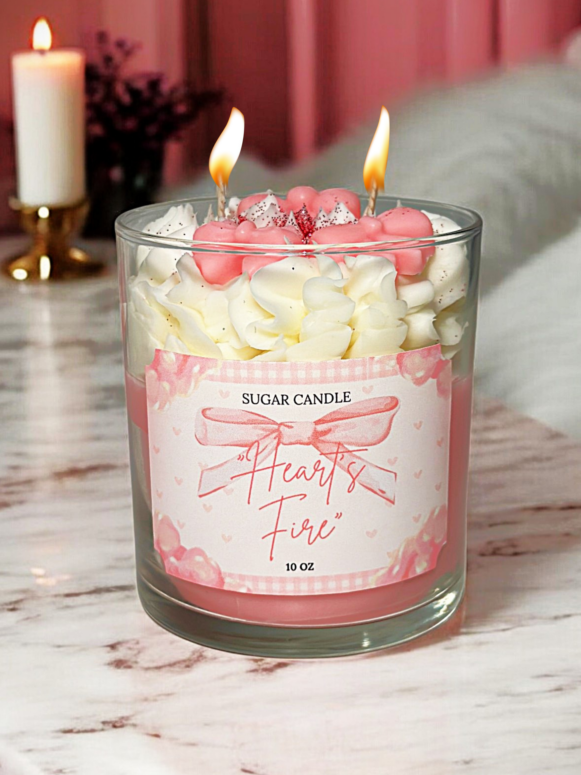Candle with pink heart-shaped candies in a glass container on a marble surface.