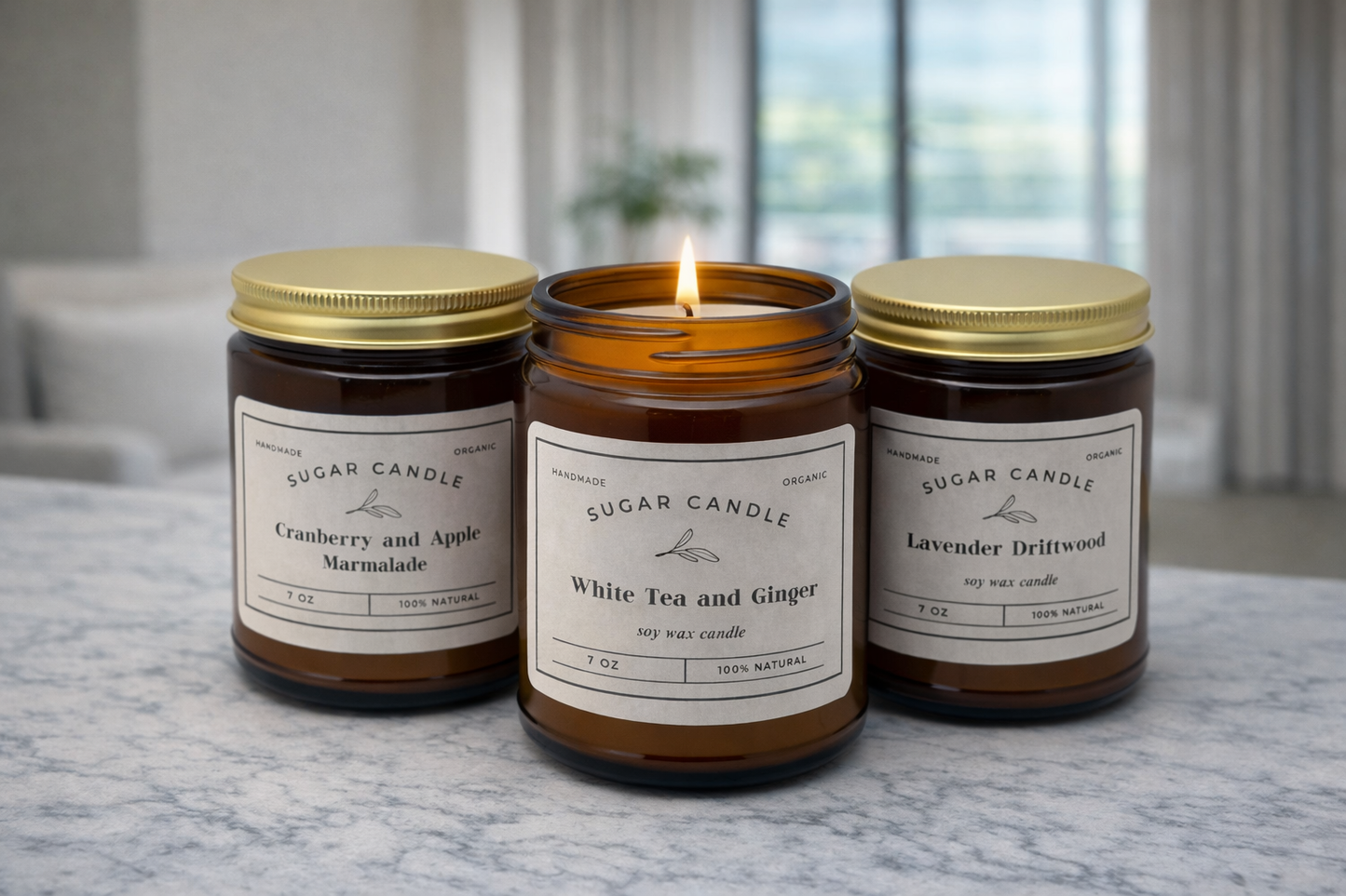 Three lit candles from Sugar Candle Company on a marble surface with a blurred indoor background.