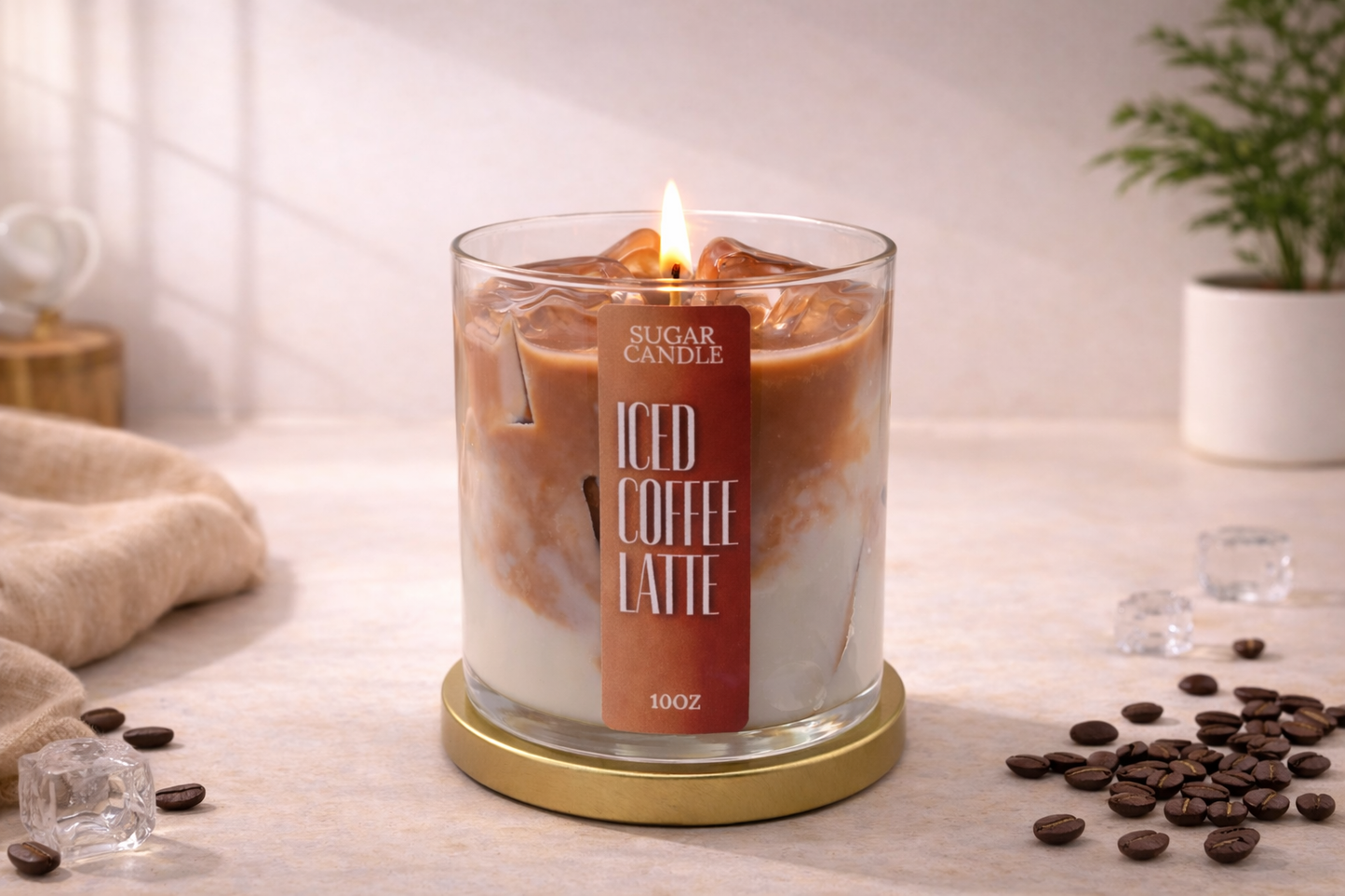 Candle labeled 'Iced Coffee Latte' with coffee beans and a plant in the background
