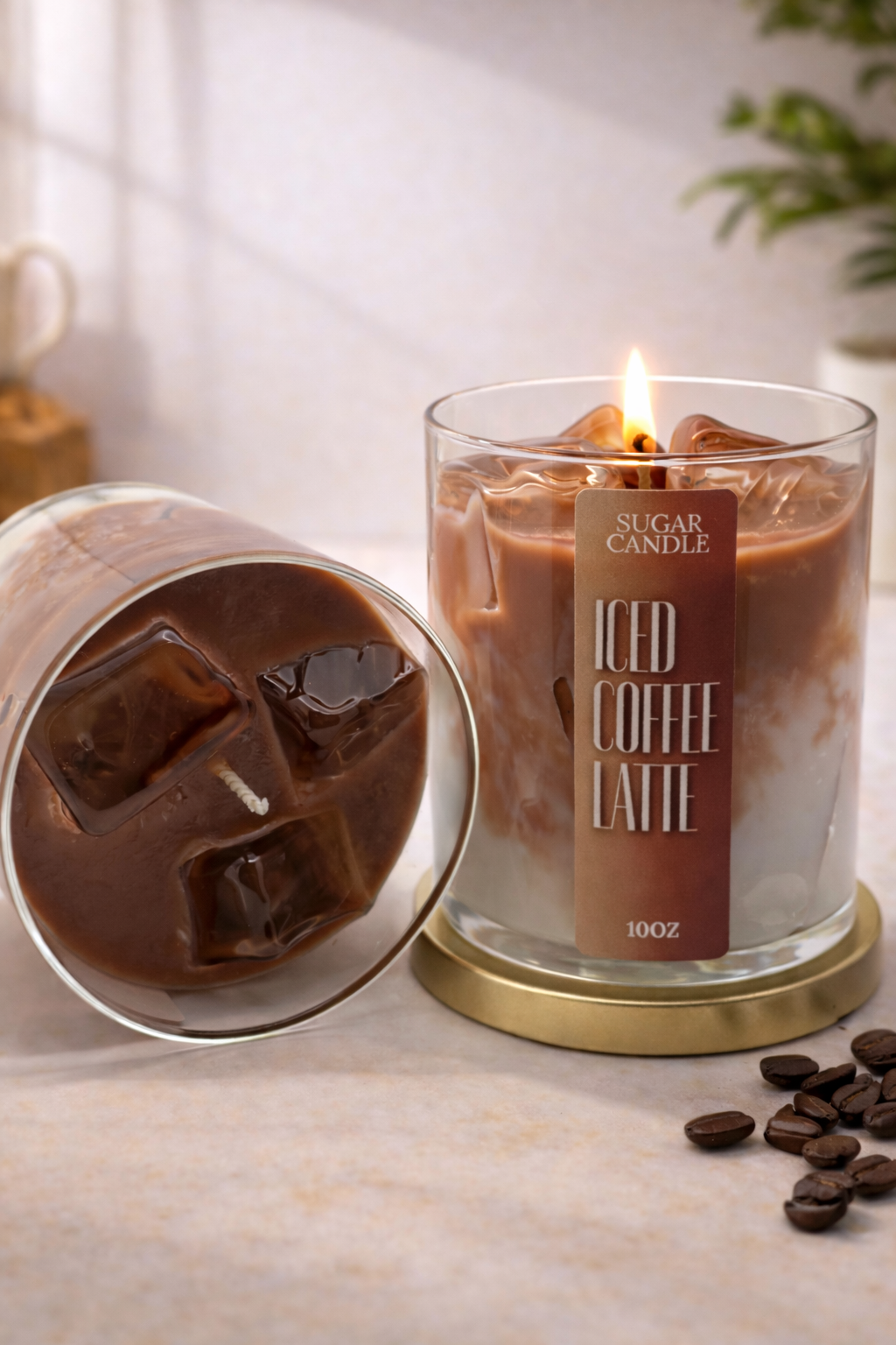 Candle labeled 'Sugar Candle Iced Coffee Latte' next to a glass of iced coffee with ice cubes on a light surface.