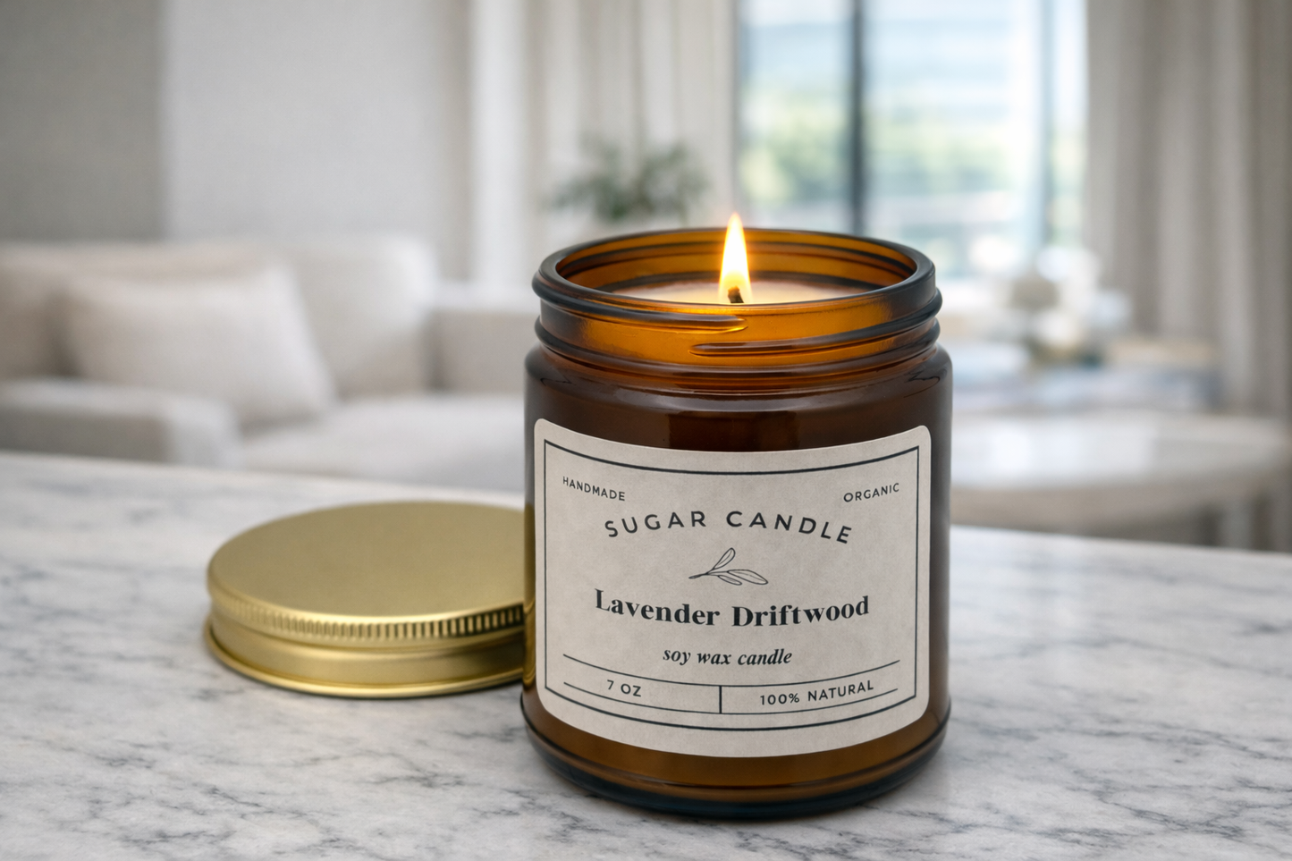 Lit candle in a glass jar with a label on a marble surface