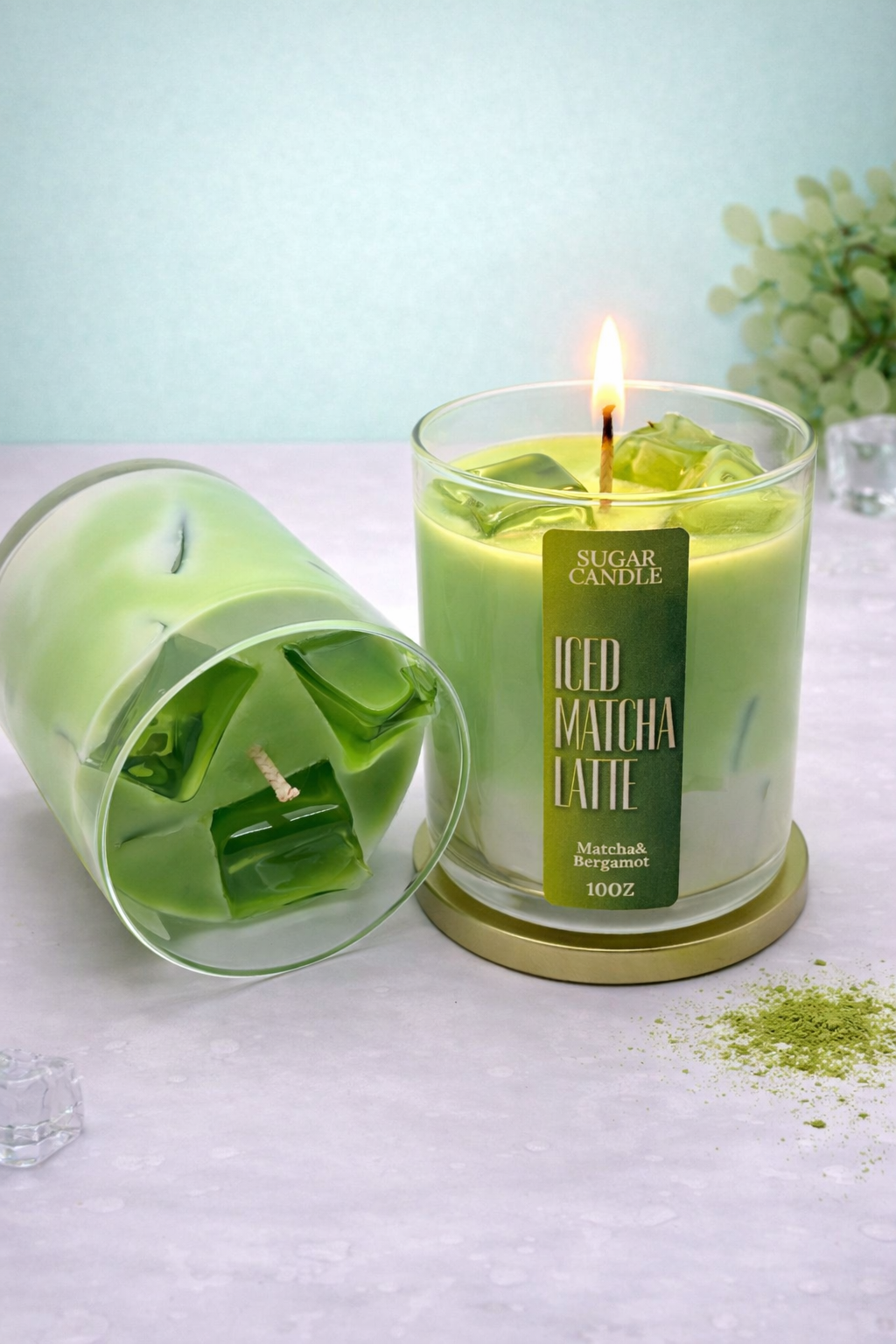 Green candle labeled 'Iced Matcha Latte' with a lit wick on a light surface.