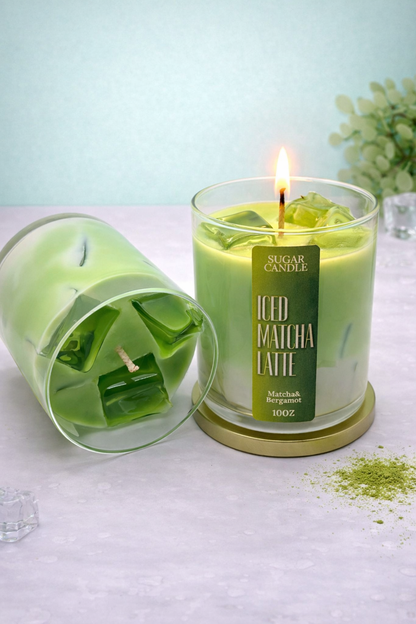 Green candle labeled 'Iced Matcha Latte' with a lit wick on a light surface.